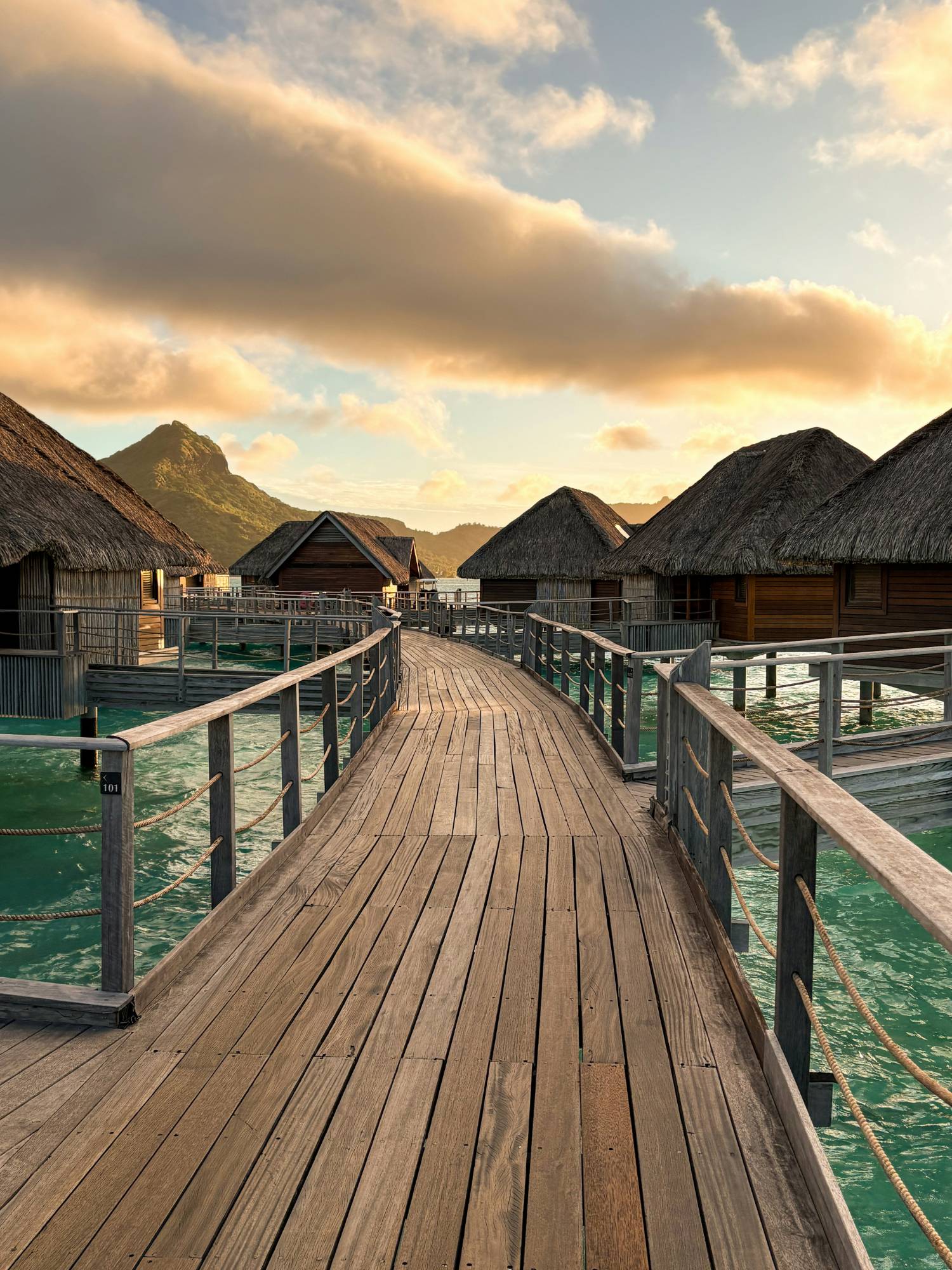 Overwater bungalow walkway at sunset in Bora Bora